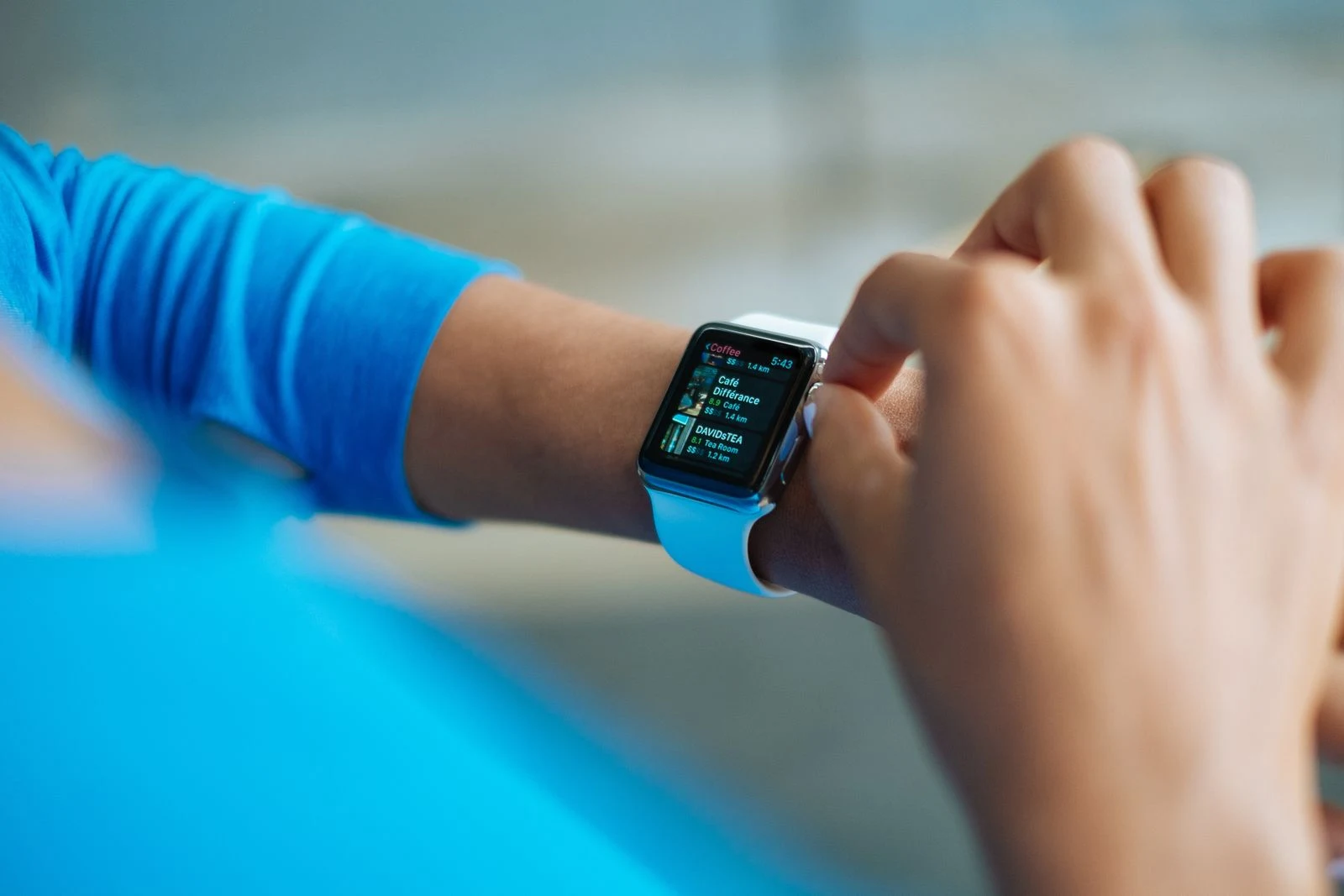 Рука касается часов для отслеживания активности во время занятия