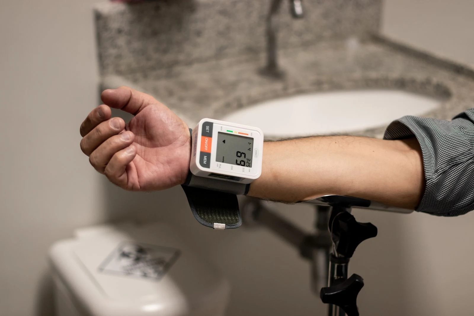 An arm wearing a wrist blood-pressure monitor